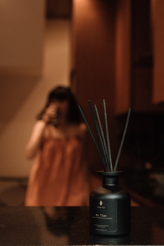 Ollie & Co. Me Time reed diffuser with black reeds on a kitchen counter