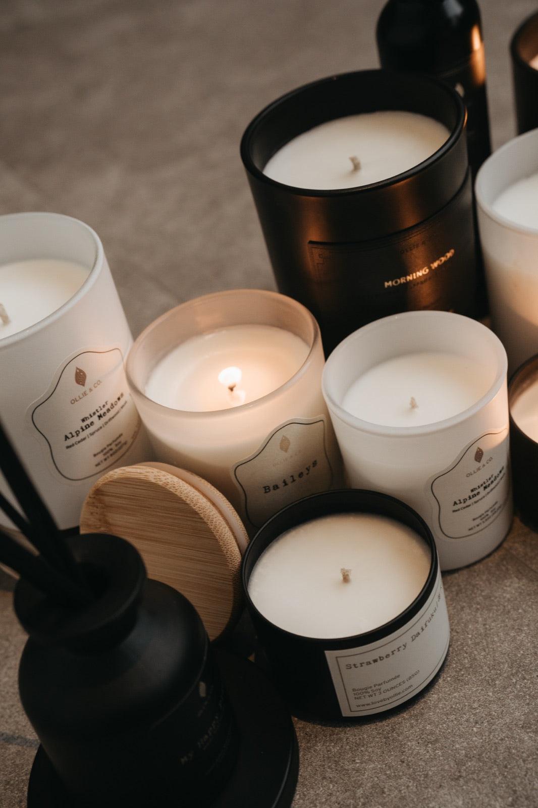 Collection of Ollie & Co. soy wax candles in white and black vessels showing creamy soy wax texture