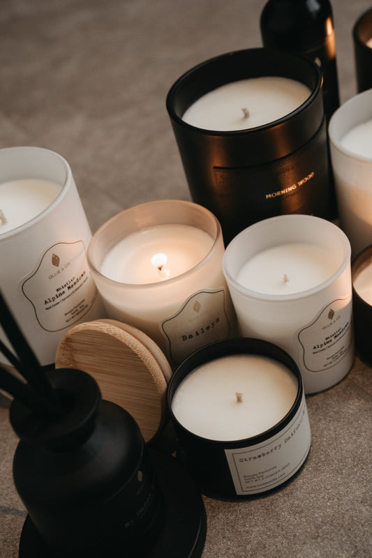 Collection of Ollie & Co. soy wax candles in white and black vessels showing creamy soy wax texture